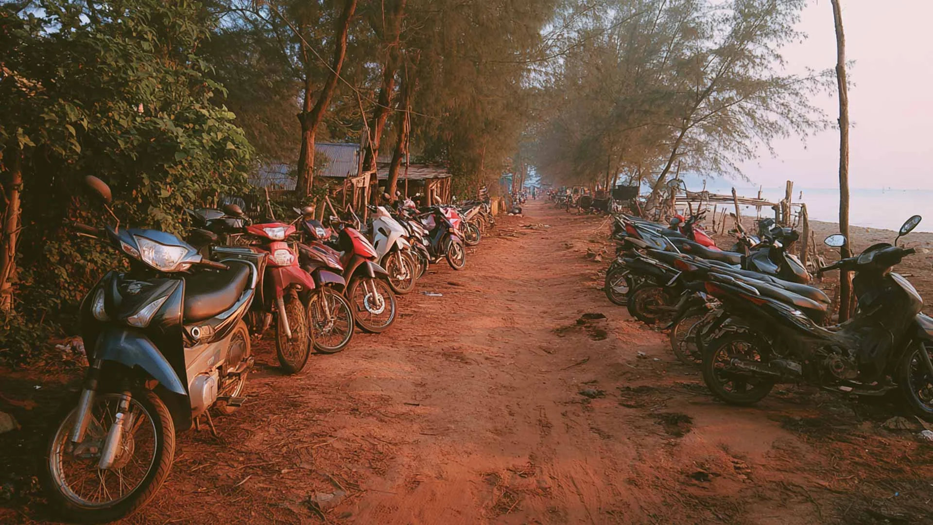 Motorbikes ands scooter parked quietly waiting for their owners to finish their day on the beach